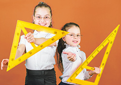 2 schoolgirls holding rulers