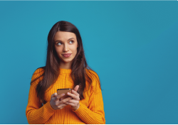 Person looking thoughtful while holding mobile device